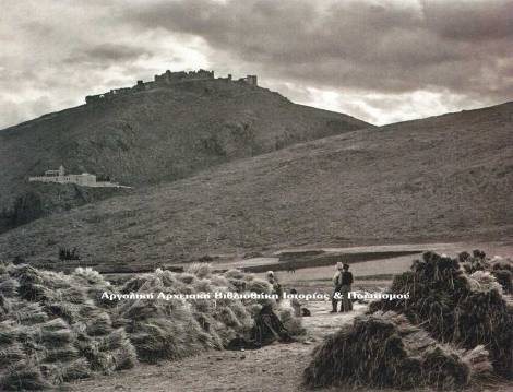 Άργος, σε πρώτο πλάνο Γεωργοί στις καθημερινές ασχολίες τους, στο βάθος το φρούριο Λάρισα του Άργους και κάτω η Ιερά Μονή Παναγίας της Κατακεκρυμμένης ή Πορτοκαλούσας. Φωτογραφία του Ελβετού Φρεντερίκ Μπουασονά (Frederic Boissonnas), περίπου το 1903. 