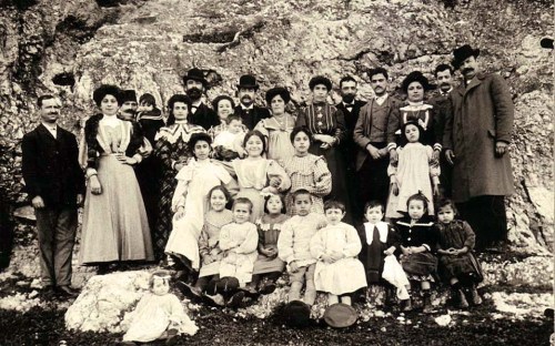 Ομαδική φωτογραφία των οικογενειών Γιουσουρούμ, Χαμπίμπ και Κοέν στο Θησείο, γύρω στο 1914. Στην πίσω γραμμή, τα πέντε παιδιά του Μποχώρ Γιουσουρούμ, Ηλίας (με μούσι και καπέλο), Χαΐμ, Ιάκωβος, Μωυσής, Νώε, με τις συζύγους και τα παιδιά τους, την τρίτη γενιά της οικογένειας. Στο κέντρο η γυναίκα του Νώε, Μαζαλτώβ (το γένος Χαμπίμπ), με τον νεογέννητο Ισαάκ στην αγκαλιά. Φωτογραφικό Αρχείο ΕΜΕ.